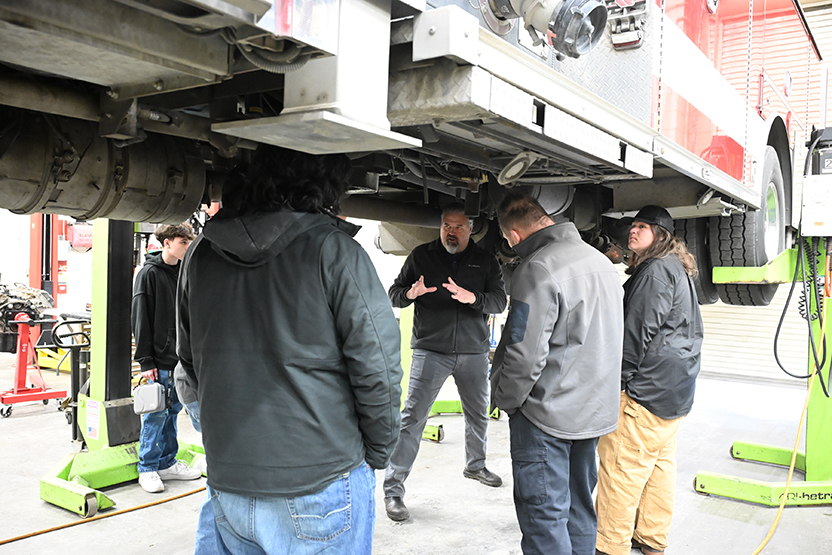 Students and educator working with a fire truck